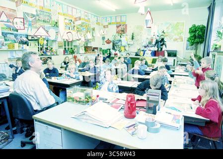 Large class, Beatrixschool, Haarlem, The Netherlands, 30-10-1996 Whizgle News, Dutch Desk, The Netherlands, 1950-2000 A classroom filled with young students engaged in various activities while a teacher instructs them at the front. Colorful artwork and educational materials decorate the walls, creating a lively learning environment. Some students are actively participating, while others appear focused on their assignments. Stock Photo