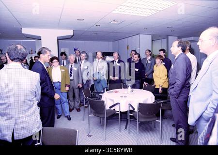 Three municipalities sign a contract with people from HCS Public automation services in the PSV stadium, 03-10-1990 Whizgle News, Dutch Desk, The Netherlands, 1950-2000 A diverse group of individuals gathers around a table, engaged in conversation and listening intently to a speaker at the forefront. The setting appears formal, likely a conference or meeting, with attendees dressed in professional attire, showcasing a mix of expressions ranging from curiosity to contemplation. Stock Photo