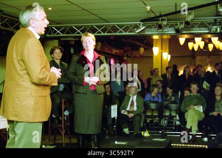 City café debate, Haarlem, The Netherlands, 03-03-2003 Whizgle News, Dutch Desk, The Netherlands, 1950-2000 A speaker addresses an audience in a lively venue, while a woman stands attentively on stage, engaging with the presentation. The crowd, seated and focused, reflects a mix of interest and anticipation in a dynamic atmosphere. Stock Photo