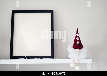 Blank wooden photo frame stands in the interior on a white background. Mockup poster frame close up in home interior.  Stock Photo