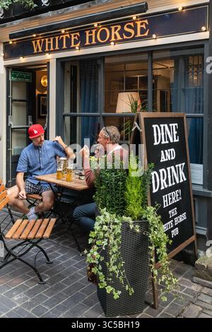 Two men enjoying drinks outside The White Horse pub in Soho, London, a popular spot for alfresco socialising in the West End. Stock Photo