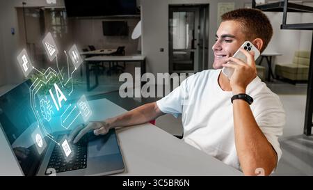 Young man engaged in technology work while talking on mobile device in modern office space Stock Photo