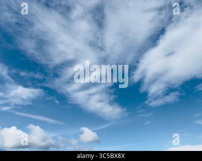 Stunning blue sky filled with puffy white clouds in a serene scene. Stock Photo