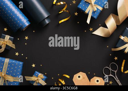Horizontal frame made of gift wrapping materials. Blue wrapping paper, tags and gold colored ribbon. Space for your text. Stock Photo