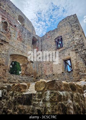 Stone ruins of the medieval Cimburk Castle in the Czech Republic, showing arched windows and crumbling walls under a partly cloudy sky. Stock Photo