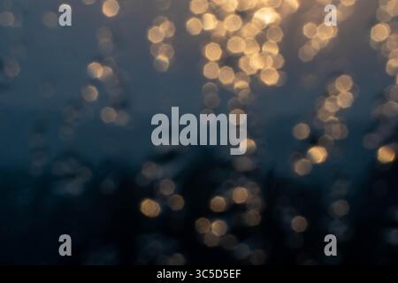 Golden light refracts through water, creating a mesmerizing abstract pattern. Stock Photo