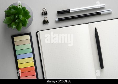 Empty notebook page for your text with black and white school and office stationery on gray background. Flatly. Stock Photo