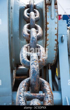Rusty anchor chain on a winch on a ship. Stock Photo