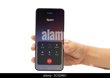 A hand holds a smartphone displaying an incoming call identified as Spam on a Stock Photo