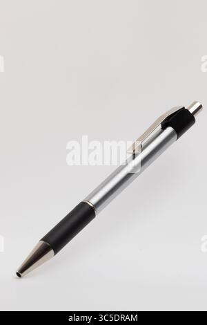A silver and black ballpoint pen is depicted on a light background. The pen  Stock Photo