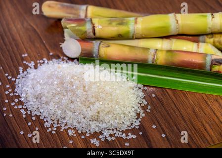 White sugar and sugar cane on wooden table background Stock Photo