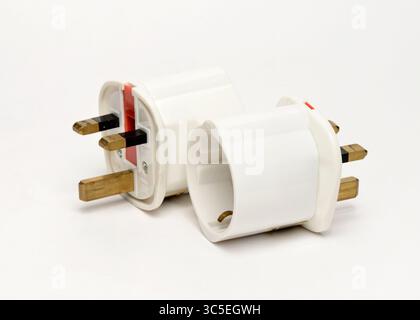European to UK plug adapters for converting EU plugs to British sockets as essential travel accessories for visitors to the United Kingdom Stock Photo