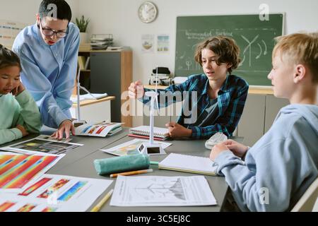 Teenage Students Collaborating on Science Project with Teacher in Classroom Stock Photo