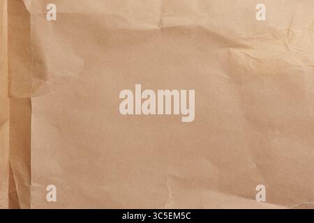 Old used parchment paper. Brown crumpled folded vintage aged surface. Abstract textured background Stock Photo
