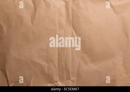 Aged creased wrunkled brown wrapping paper texture with old worn folds. Abstract vintage background Stock Photo
