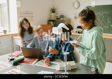 Diverse Teenagers Collaborating on Renewable Energy Project Using Virtual Reality Stock Photo