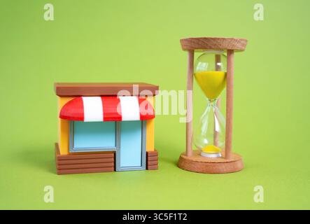 Shop and hourglass. Commercial premises for rent. Deadline for reporting. Urgency in commercial leasing decisions. Financial pressure. Approaching dea Stock Photo