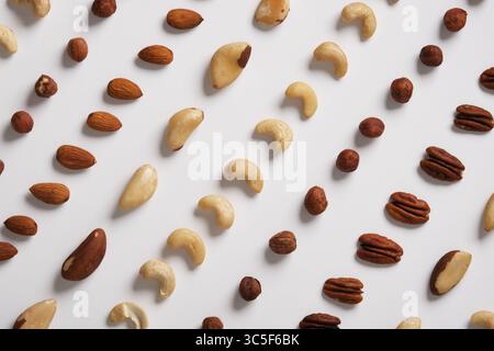 Background of different nuts on a white backdrop. Almonds, cashews, hazelnuts, Brazil nuts, pecans. Stock Photo