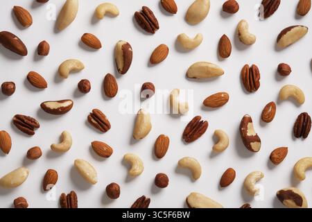 Background of different nuts on a white backdrop. Almonds, cashews, hazelnuts, Brazil nuts, pecans. Stock Photo