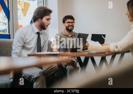 Colleagues engaging in lively discussion during a collaborative office meeting Stock Photo