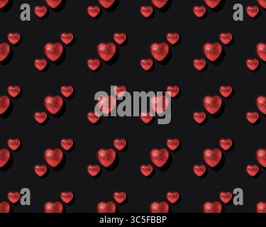 Pattern of red shiny hearts on black background. Valentine's Day card Stock Photo