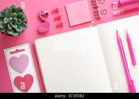 Blank notebook page for your text with pink school and office stationery on magenta background. Flatly. Stock Photo