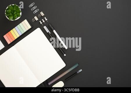 Card with black, white and gray school and office stationery and note on black background. Flatly, copyspace. Stock Photo
