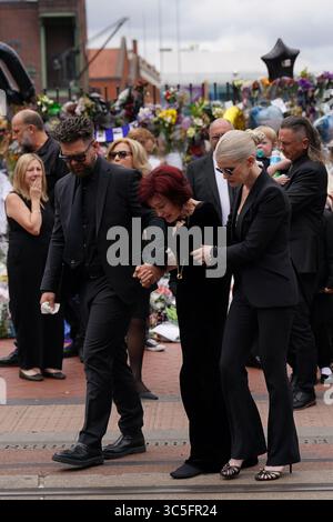 The family of Ozzy Osbourne (left to right) Jack, Sharon and Kelly Osbourne, view the messages and floral tributes left at the Black Sabbath Bridge bench on Broad Street in Birmingham in memory of Black Sabbath frontman Ozzy Osbourne, as his body is brought back to his home city for a procession following his death last week aged 76. Picture date: Wednesday July 30, 2025. Stock Photo