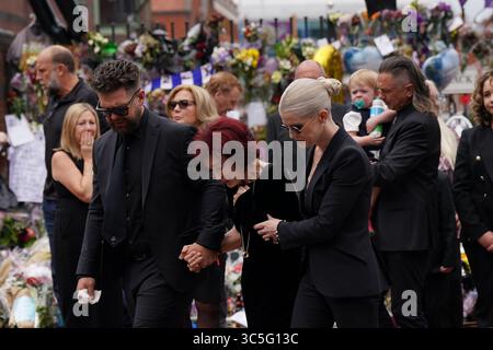 The family of Ozzy Osbourne (left to right) Jack, Sharon and Kelly Osbourne, view the messages and floral tributes left at the Black Sabbath Bridge bench on Broad Street in Birmingham in memory of Black Sabbath frontman Ozzy Osbourne, as his body is brought back to his home city for a procession following his death last week aged 76. Picture date: Wednesday July 30, 2025. Stock Photo