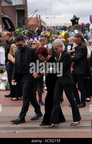 The family of Ozzy Osbourne (left to right) Jack, Sharon and Kelly Osbourne, view the messages and floral tributes left at the Black Sabbath Bridge bench on Broad Street in Birmingham in memory of Black Sabbath frontman Ozzy Osbourne, as his body is brought back to his home city for a procession following his death last week aged 76. Picture date: Wednesday July 30, 2025. Stock Photo