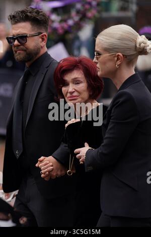 The family of Ozzy Osbourne (left to right) Jack, Sharon and Kelly Osbourne, view the messages and floral tributes left at the Black Sabbath Bridge bench on Broad Street in Birmingham in memory of Black Sabbath frontman Ozzy Osbourne, as his body is brought back to his home city for a procession following his death last week aged 76. Picture date: Wednesday July 30, 2025. Stock Photo