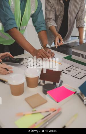 architects and engineers are discussing the design and structure of the upcoming building with the foreman to ensure that they understand the details Stock Photo