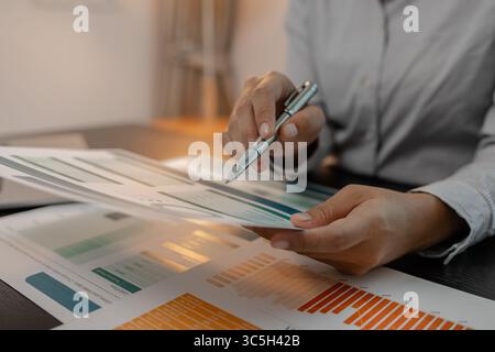 businessman is checking financial documents to match the information summarized by the accounting department, accountant, marketing department, workin Stock Photo