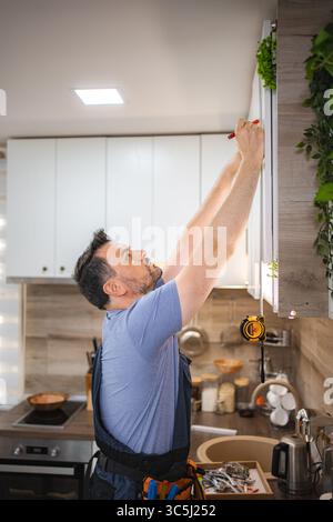 Carpenter working on a new kitchen furniture installation Stock Photo