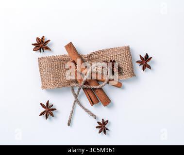 This top view image showcases beautifully arranged cinnamon sticks and star anise on a pristine white background. Ideal for culinary, seasonal, or aro Stock Photo