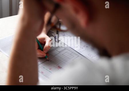 A collaborative team of architects and designers engaged in a focused meeting, actively drawing and discussing a new interior design plan. essence of Stock Photo