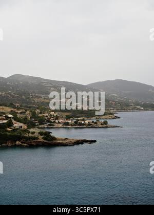 Scenic and moody view of Zante’s coastline, featuring cliffs, sea caves, and vivid homes under heavy cloud cover. Stock Photo