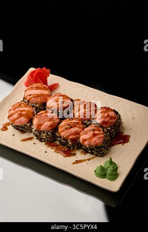 Sushi on a black background. Sushi rolls with salmon, caviar, cream cheese and sauce Stock Photo
