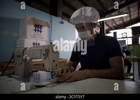 March 25, 2020, Tehran, Iran: Iranian workers wearing face masks work at a protective mask and garment sewing workshop that is belonging to the Iranian Red Crescent, in the west of Tehran, following the new coronavirus (Covid-19) outbreak in Iran. In recent days, Iran has ordered the closure of nonessential businesses and banned travel between cities. But those measures came long after other countries in the region imposed more sweeping lockdowns. Iran has urged the international community to lift sanctions and is seeking a $5 billion loan from the International Monetary Fund. (Credit Image: © Stock Photo