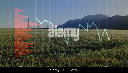 Displaying grid overlay and charts over cereal crops at wind farm, with turbines and mountains Stock Photo