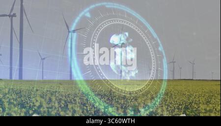 Projecting holographic circular interface displaying globe over wind farm flowering crop field Stock Photo