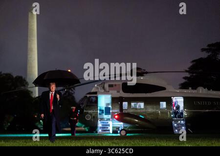 May 5, 2020 - Washington, District of Columbia, U.S. - President DONALD TRUMP carries an umbrella as he disembarks Marine One on the South Lawn of the White House Tuesday evening returning from his trip to Honeywell International in Phoenix. (Credit Image: © White House/ZUMA Wire/ZUMAPRESS.com) Stock Photo