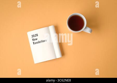 2026 New Resolutions on open notepad, next to cup of coffee. Top view. Stock Photo