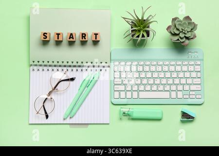 Cubes with text START, notebook and eyeglasses on green background. Top view Stock Photo
