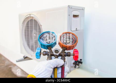 Technician checking the operation of the air conditioner Stock Photo
