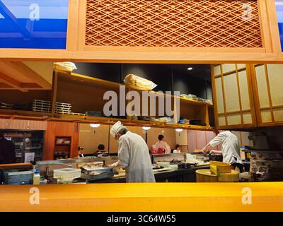 Sushi Chefs Preparing Dishes Behind Counter in Osaka Restaurant, Japan Stock Photo