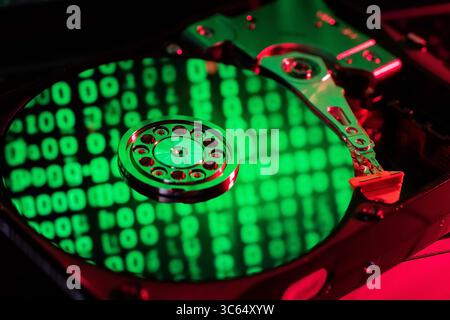 moving hard drive head with green data on drive Stock Photo