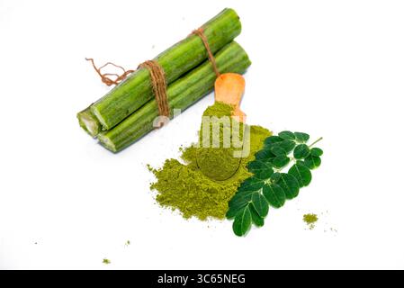 Moringa oleifera powder in wooden spoon with fresh real moringa leaves isolated on white background Stock Photo