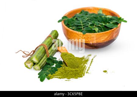 Moringa oleifera powder in wooden spoon with fresh real moringa leaves isolated on white background Stock Photo