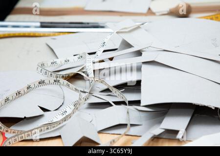 A measuring tape is currently resting on top of a pile of cardboard, Stock Photo